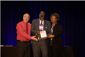Photo of Moustapha Diack and Robbie Melton accepting award for Mary Teuw Niane.